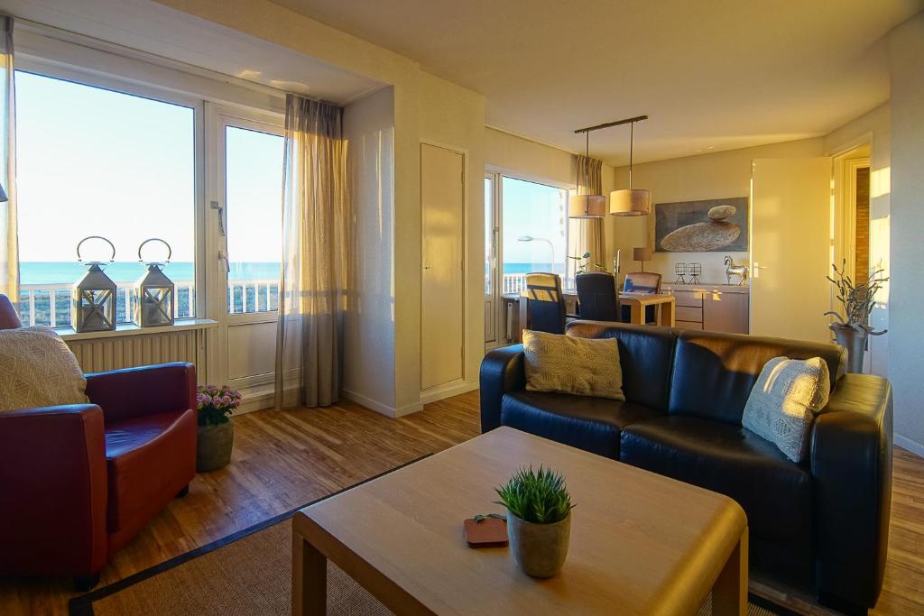 滨海卡特韦克Appartementen Zeezicht - 3的客厅配有两张沙发和一张桌子
