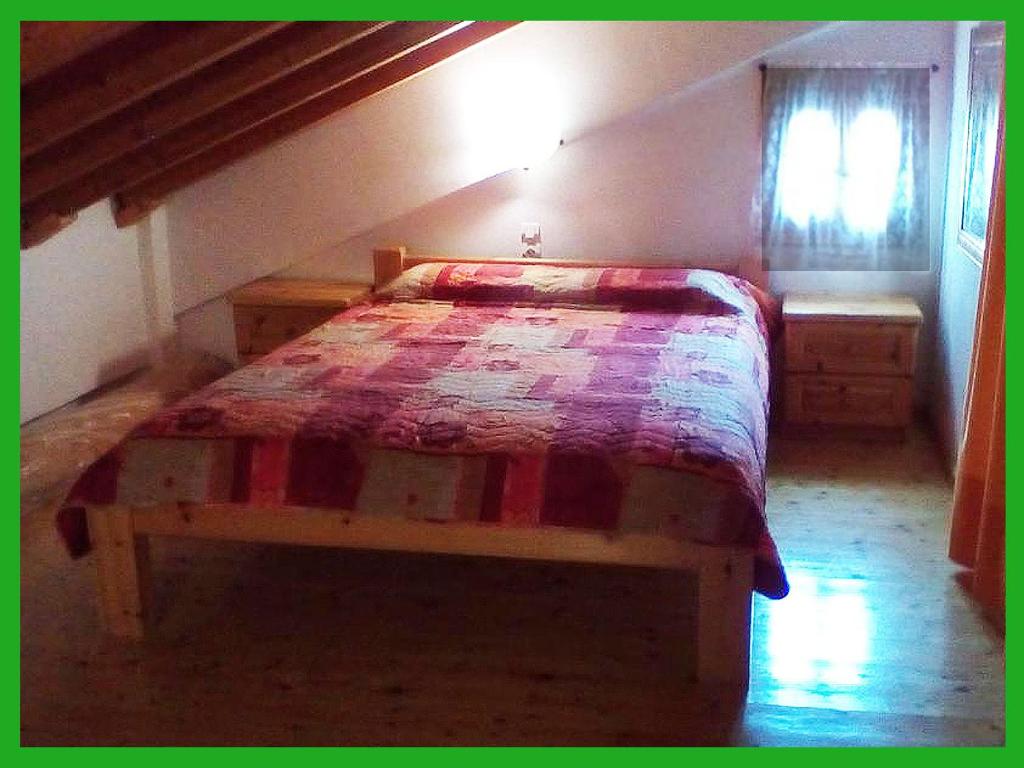 埃夫迪洛斯Kampos View Ikaria的一间卧室,卧室内配有一张木床