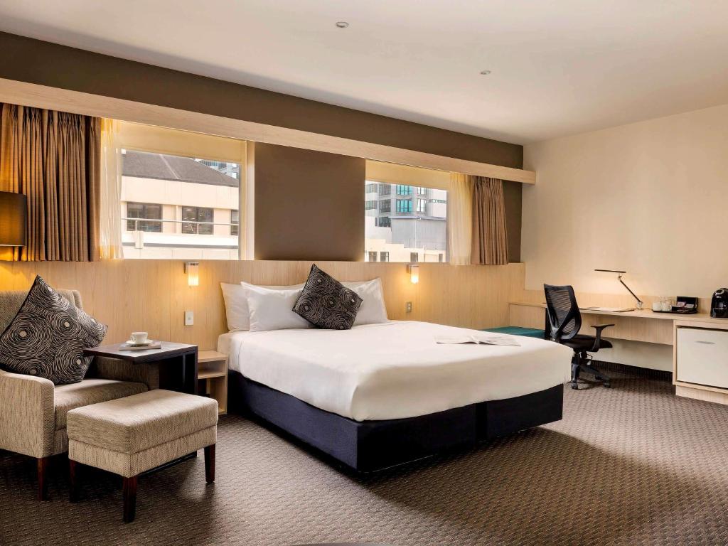 惠灵顿惠灵顿宜必思酒店的酒店客房设有一张大床和一张书桌。