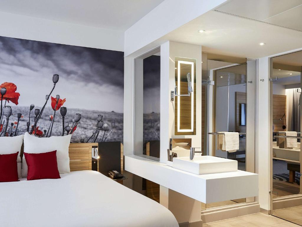 伊普尔诺富伊珀尔中心酒店的一间带白色大床的卧室和一间浴室