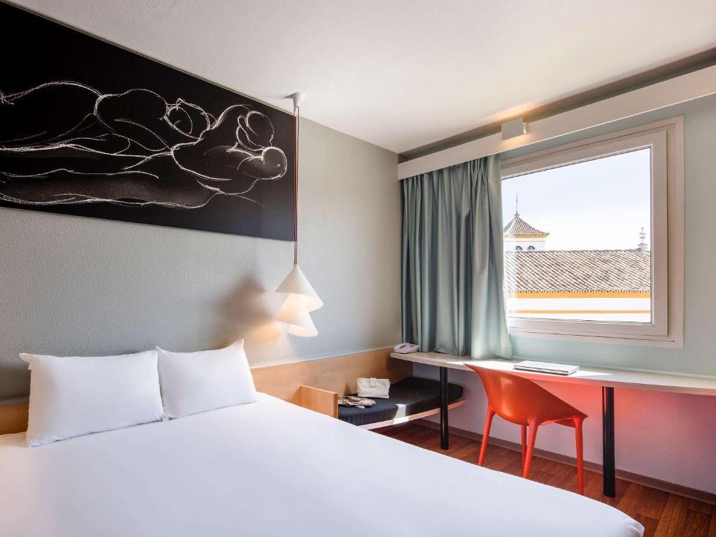 塞维利亚宜必思塞维利亚酒店的配有一张床、一张书桌和一扇窗户的酒店客房