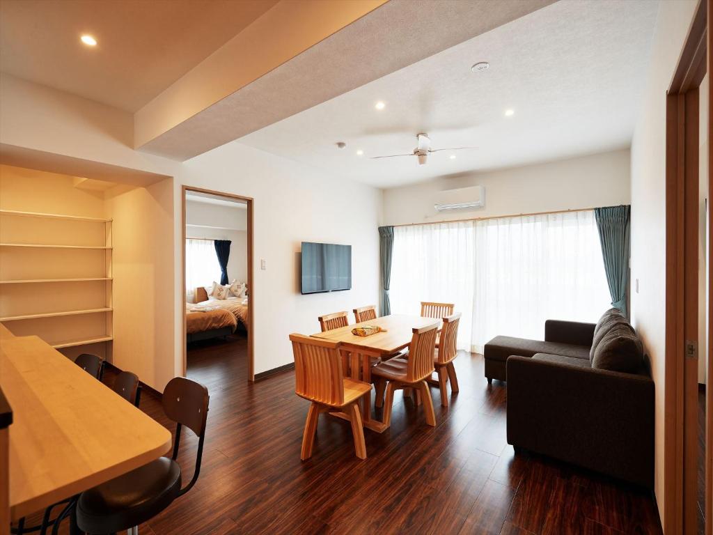 北谷町M´s Stay Okinawa的客厅配有桌子和沙发