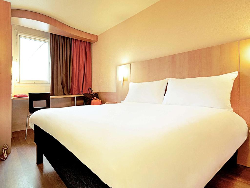 阿布维尔宜必思阿布维尔酒店的一张大白色床,位于酒店带窗户的房间内