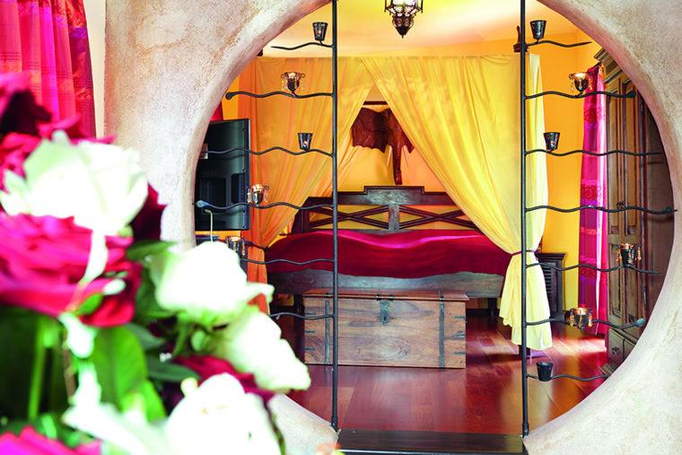 坎德尔Zum Riesen的一间卧室配有一张带窗帘和鲜花的床