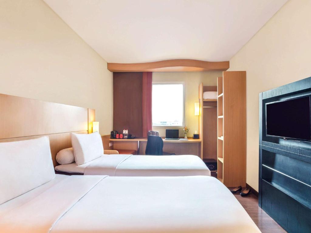 泗水泗水市中心宜必思酒店的酒店客房设有两张床和一台平面电视。