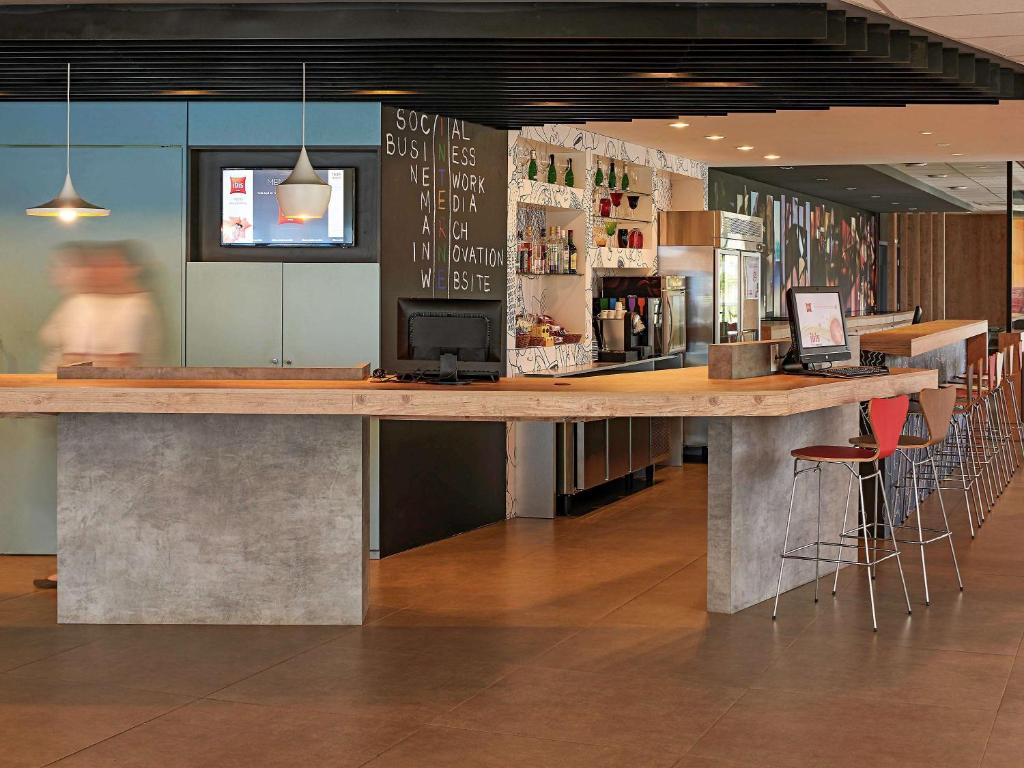 隆德里纳隆德里纳宜必思酒店的一间设有酒吧凳子的餐厅里的大型木制酒吧