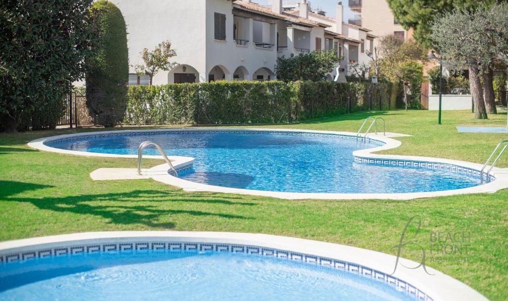 卡拉费尔Casa adosada 50m de la playa Calafell . WIFI gratis的一座游泳池,位于一座带建筑物的庭院内