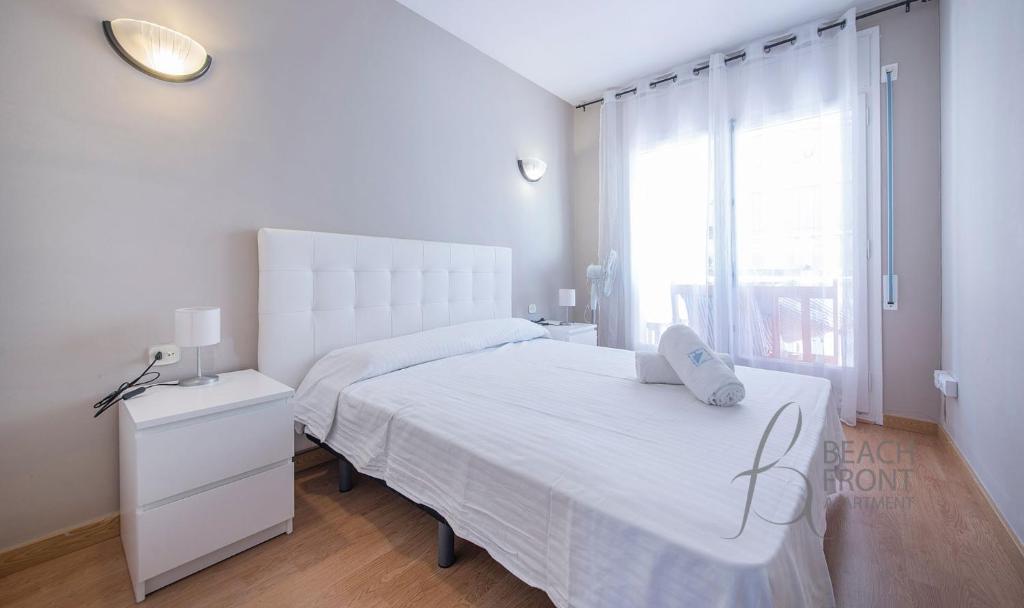 卡拉费尔Apartamento Montserrat 32-2的白色的卧室设有白色的床和窗户。