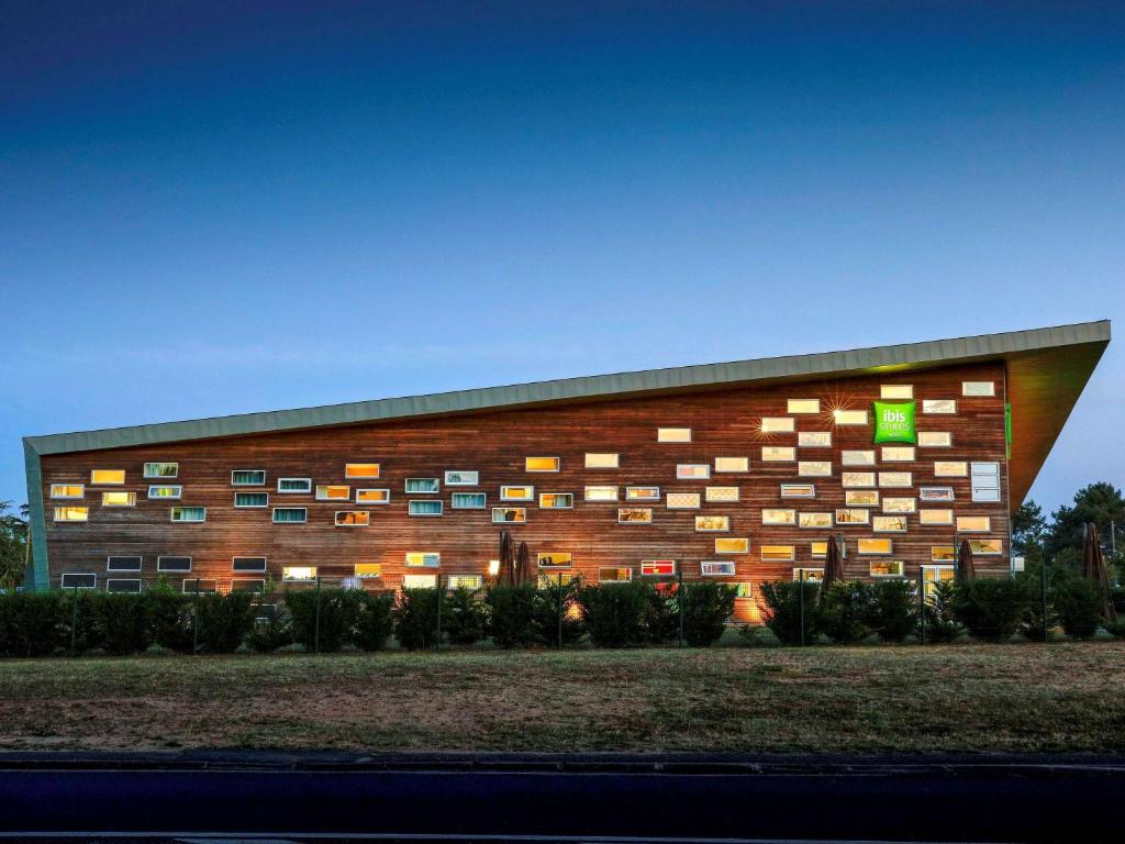 米萨讷南勒芒 - 慕尚基里亚德酒店的砖砌的建筑,上面有绿色的标志