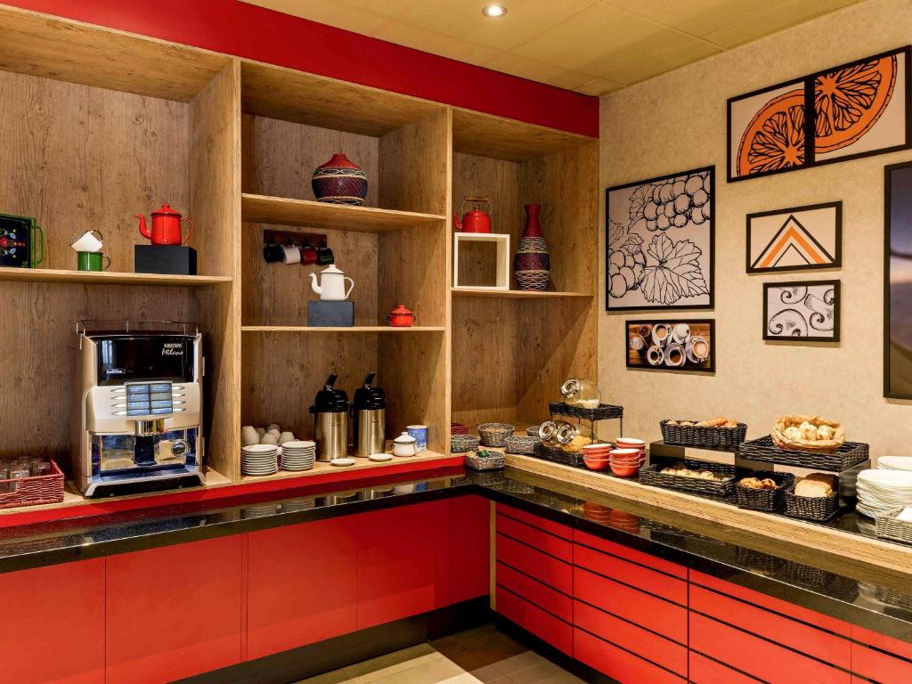 圣贝尔纳多-杜坎普ibis Sao Bernardo do Campo的厨房配有红色橱柜和带微波炉的台面