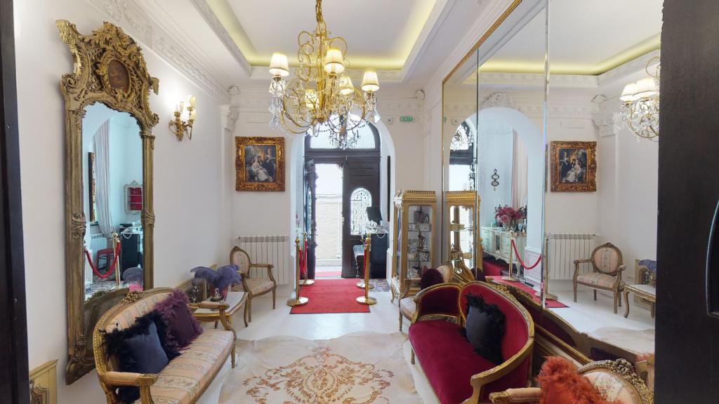 布加勒斯特Conacul Coroanei Luxury Boutique Hotel的客厅配有家具和吊灯。