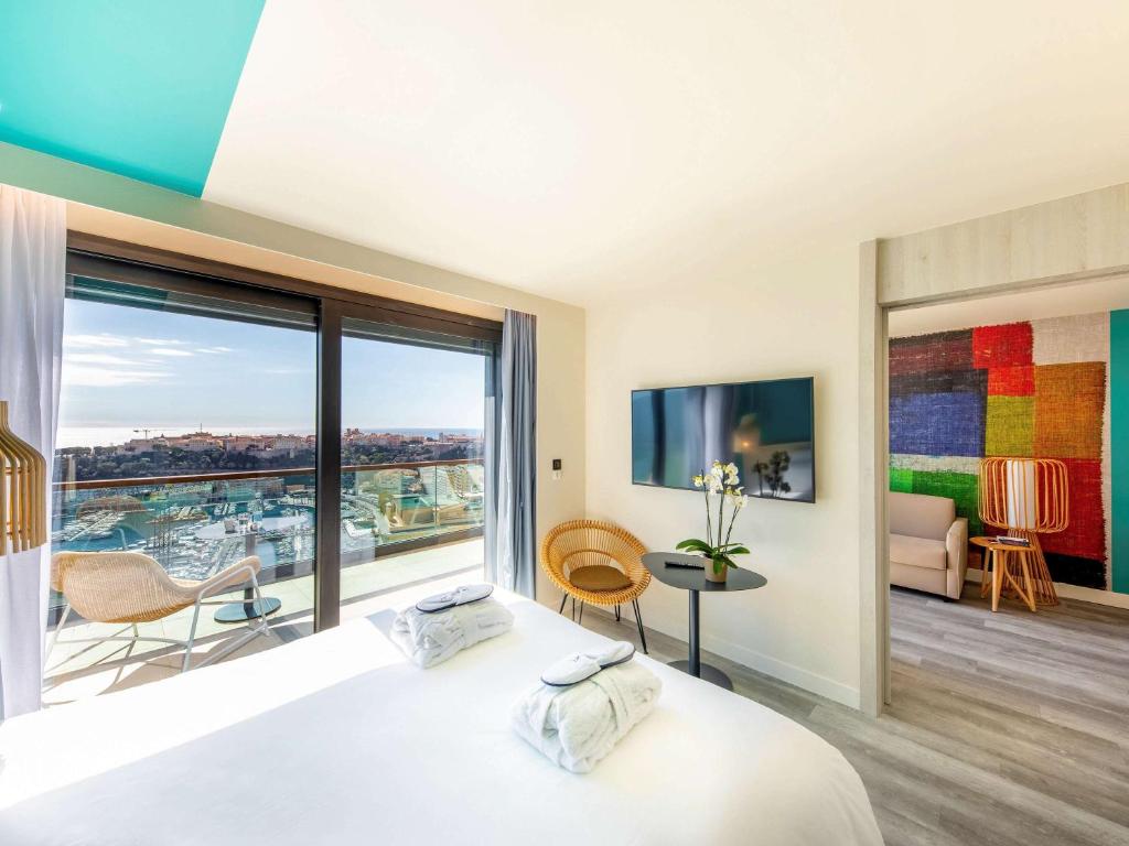 蒙特卡罗蒙特卡罗诺富特酒店的一间卧室设有一张床和一个大窗户