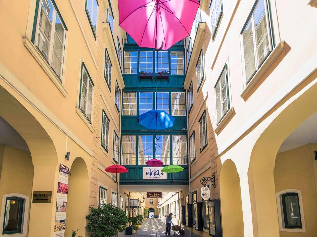 维也纳美居维也纳毕德迈亚大酒店的一座楼里挂着遮阳伞的小巷