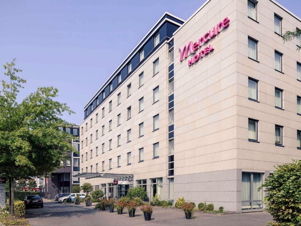 杜塞尔多夫杜塞尔多夫城北美居酒店的一座白色的大建筑,上面有粉红色的标志