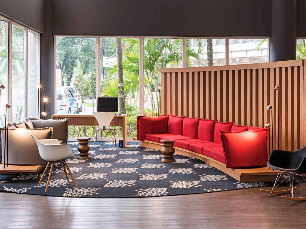 圣安德雷ibis Santo Andre的客厅配有红色沙发和钢琴