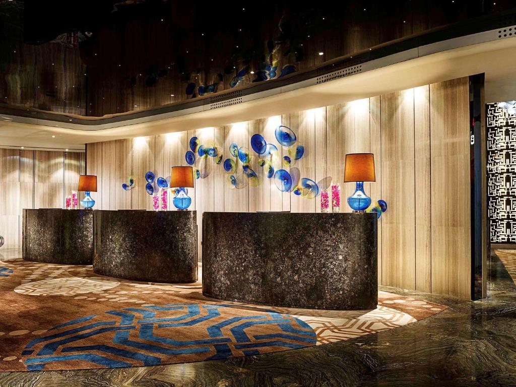 南京南京苏宁索菲特银河大酒店的墙上有蓝色和白色花瓶的大堂