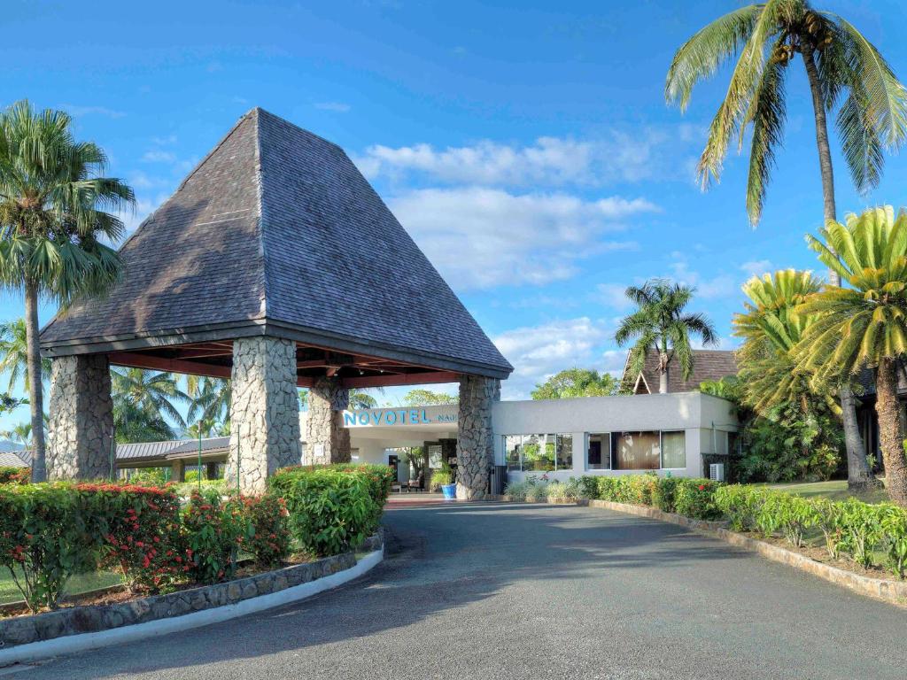 南迪诺富特纳迪酒店的一座带凉亭和棕榈树的建筑