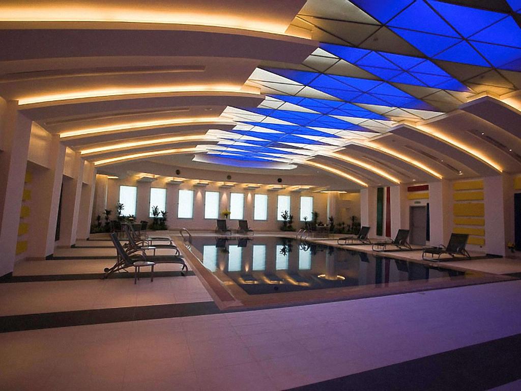 利雅德利雅得奥诺德诺沃特酒店的中间设有游泳池的大型建筑
