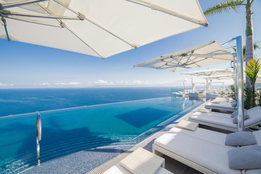 巴亚尔塔港姆赛酒店 - 仅限成人的一个带白色躺椅的游泳池以及大海