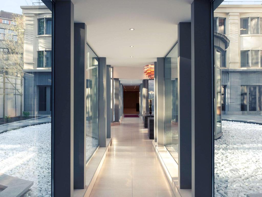 布鲁塞尔布鲁塞尔中心米迪美居酒店的带有玻璃墙的建筑走廊