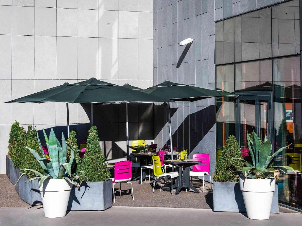 里昂里昂中央宜必思尚品酒店 - 火车东站店 的一个带桌椅和遮阳伞的庭院