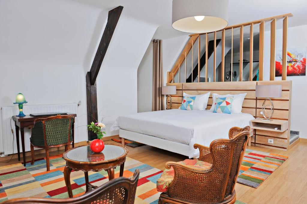 圣樊尚德科塞La noyeraie du port d'enveaux的卧室配有一张床和一张桌子及椅子