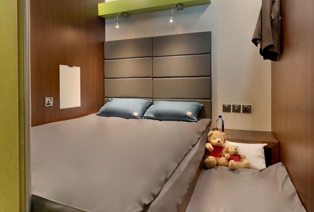 多哈sleep 'n fly Sleep Lounge, SOUTH Node - TRANSIT ONLY的一张大床,上面有泰迪熊