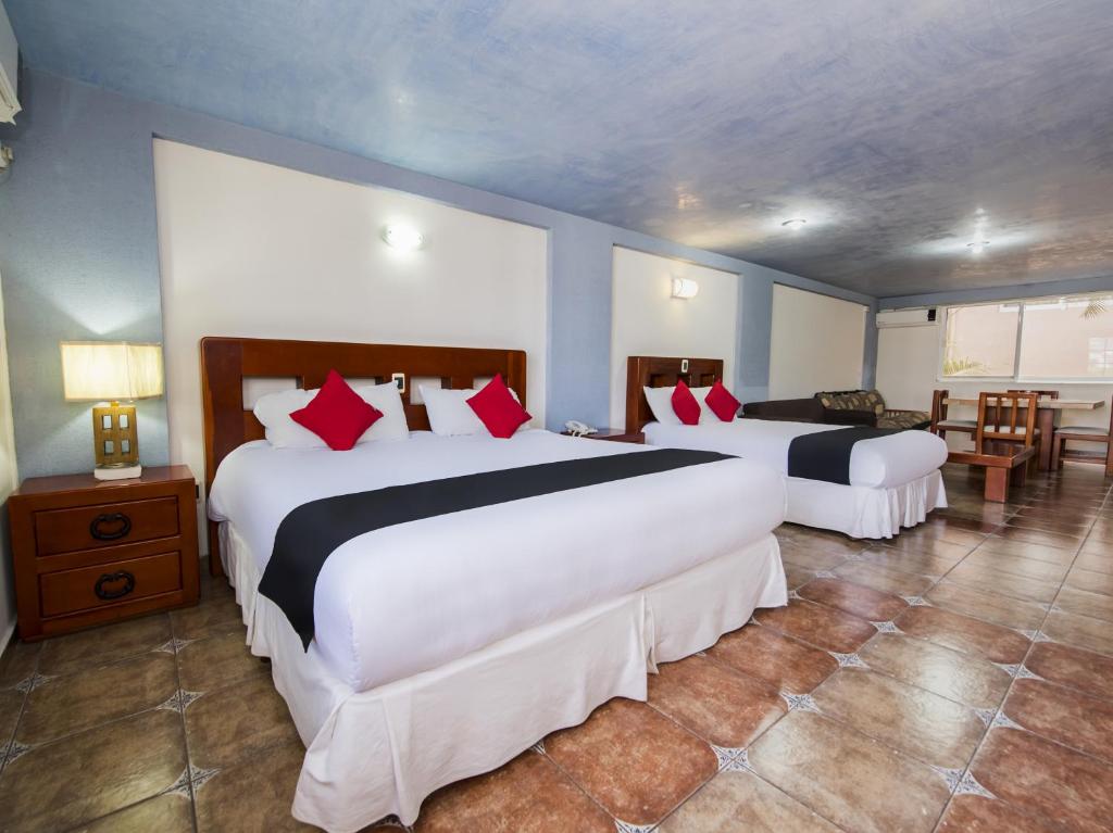 伊拉普阿托Suites de Reyes的酒店客房 - 带两张大床和红色枕头