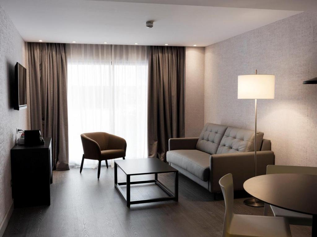 巴塞罗那巴塞罗那HG城市套房酒店的客厅配有沙发和桌子