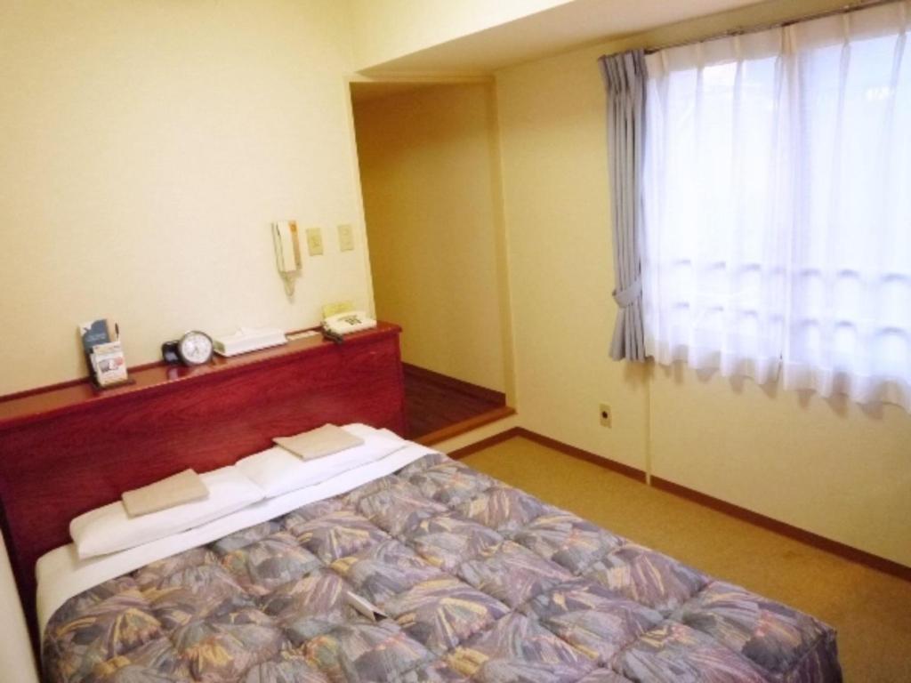 川崎Sky Heart Hotel Kawasaki / Vacation STAY 80809的一间卧室设有一张床和一个窗口