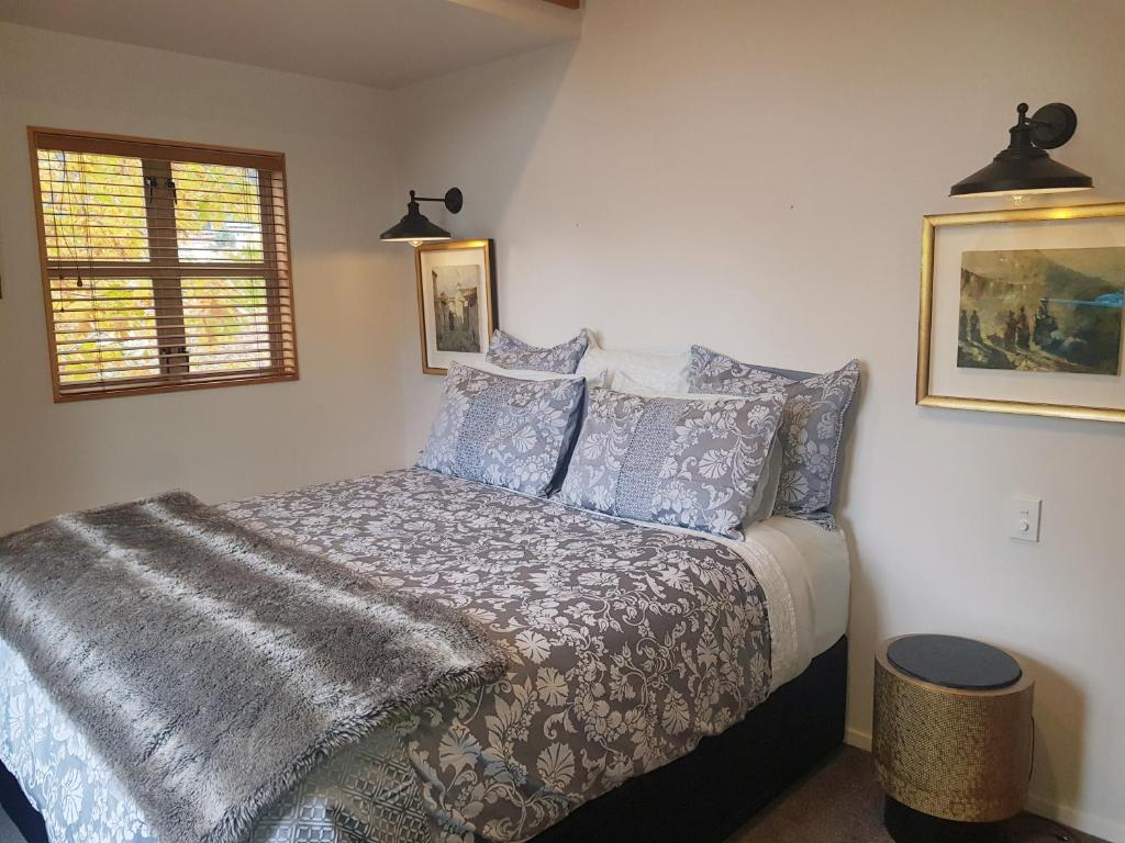 皇后镇Villa 10 - Central Stylish Apartment的一间卧室配有一张带毯子和枕头的床。