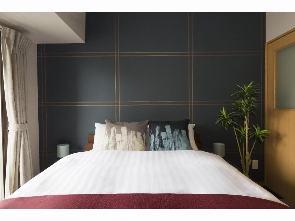 长崎Coruscant Hotel Nagasakieki的一间卧室设有一张大床和蓝色的墙壁