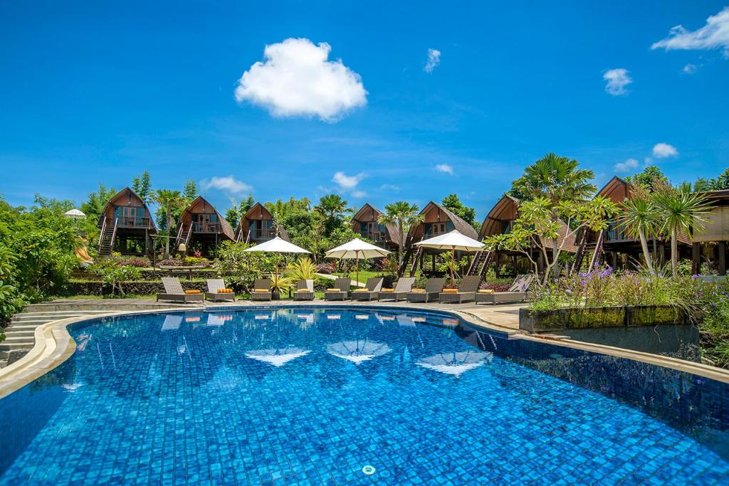 金巴兰基拉纳昂格桑别墅的度假村的游泳池,配有椅子和遮阳伞