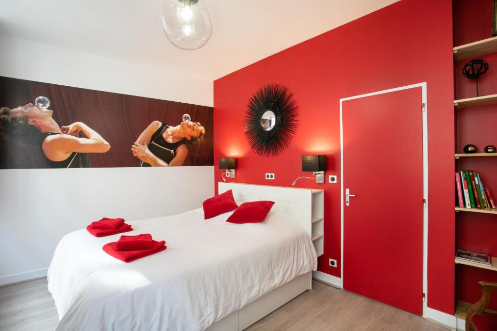 佩里格Corps et graphi(qu)es的卧室设有红色的墙壁和一张带红色枕头的白色床。
