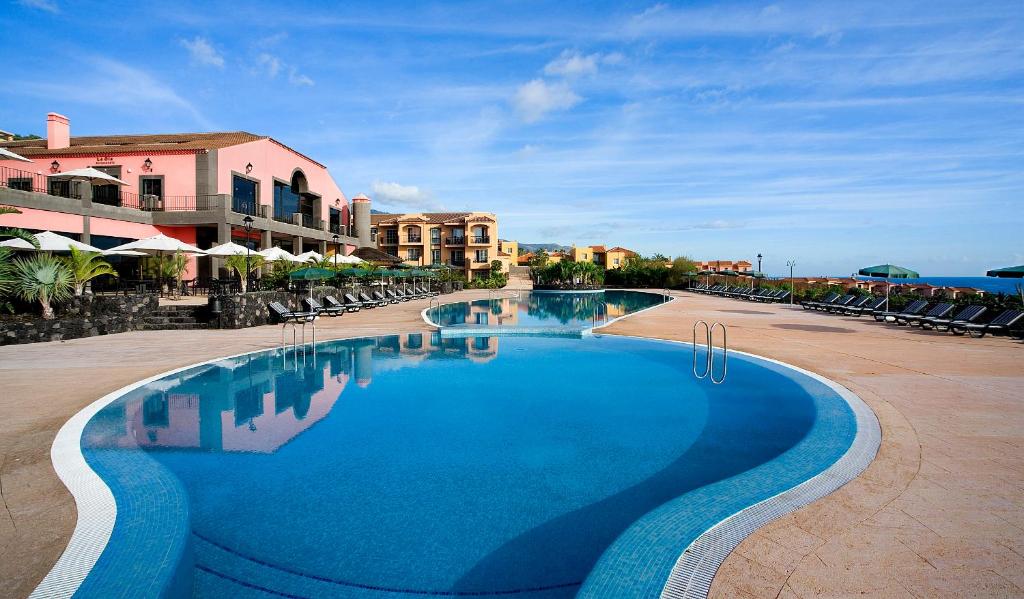 洛思坎加约斯冲浪公寓酒店的度假村内的一个蓝色海水游泳池