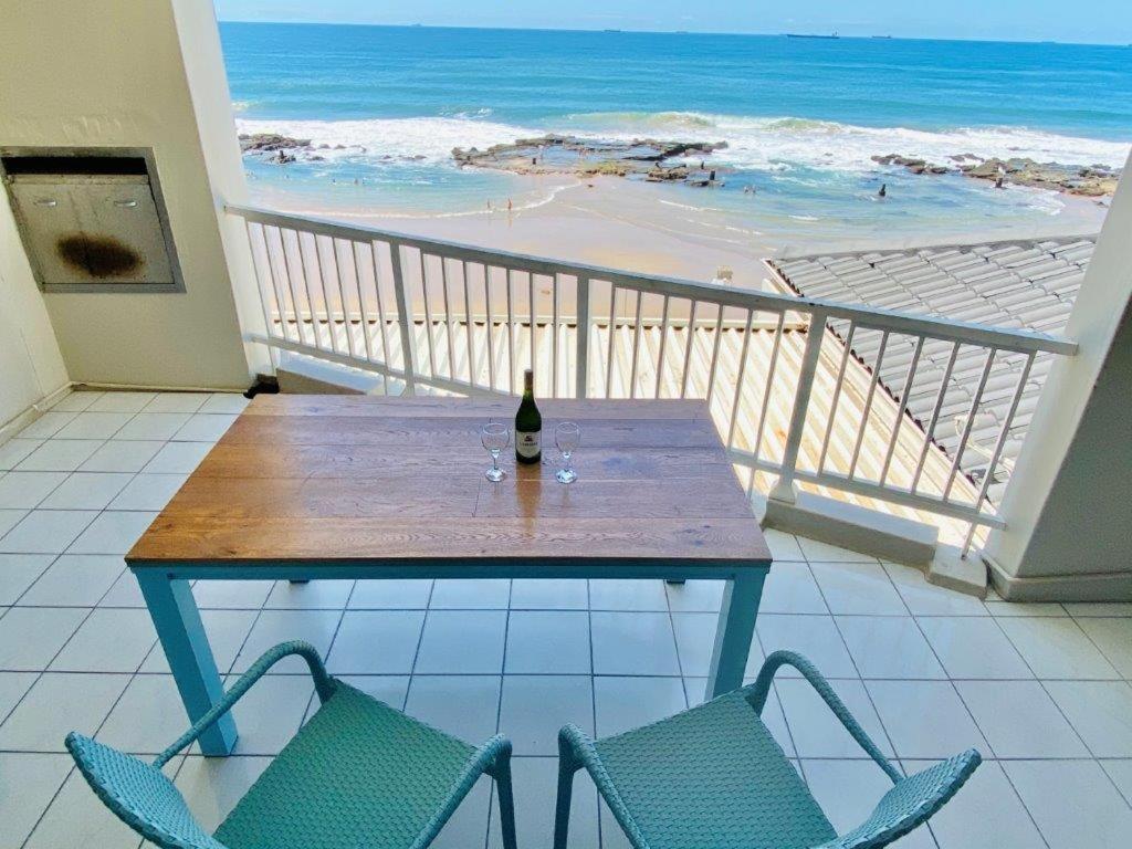 乌姆德洛蒂Sorgente 304 with Inverter的海滩阳台的桌子和一瓶葡萄酒