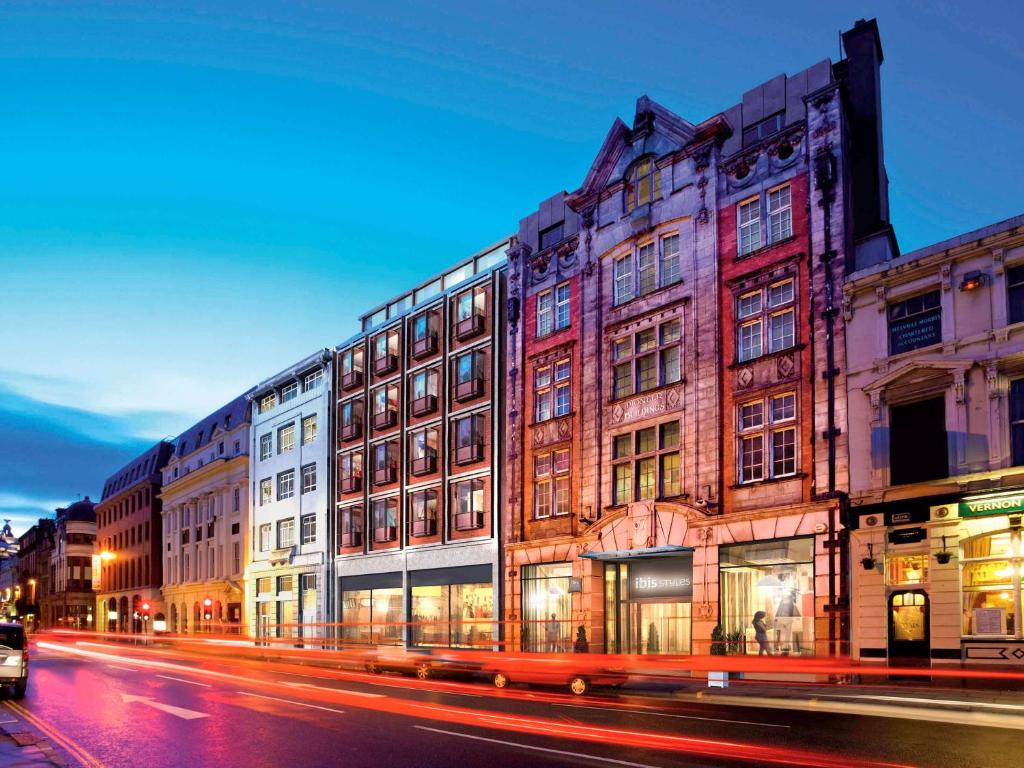 利物浦利物浦中心戴尔街宜必思尚品酒店 - 卡文区的夜幕降临的城市街道上的一排建筑物