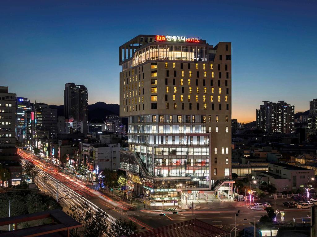 釜山宜必思大使釜山城市中心酒店的一座高大的建筑,上面有标志
