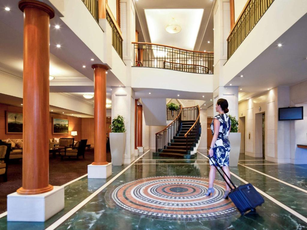 奥克兰奥克兰西码头塞贝尔酒店的带着行李穿过酒店大堂的女人