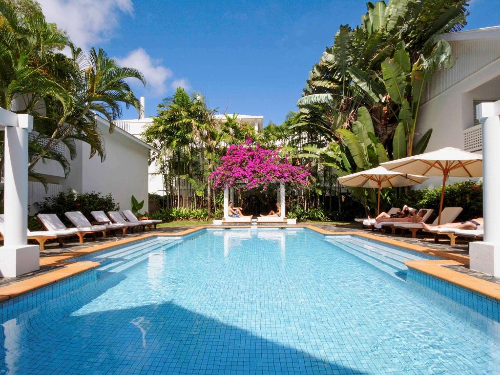 棕榈湾The Reef House Adults Retreat - Enjoy 28 Complimentary Inclusions的度假村的游泳池配有椅子和遮阳伞