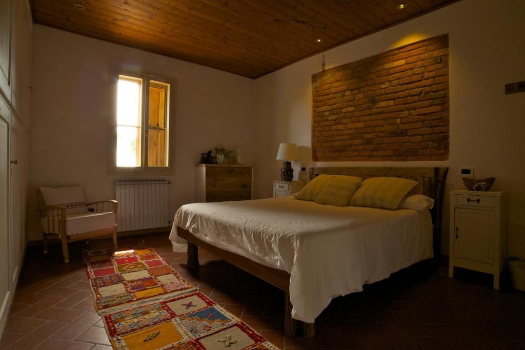 BevazzanaB&B Casa Volton的一间卧室设有一张床和砖墙