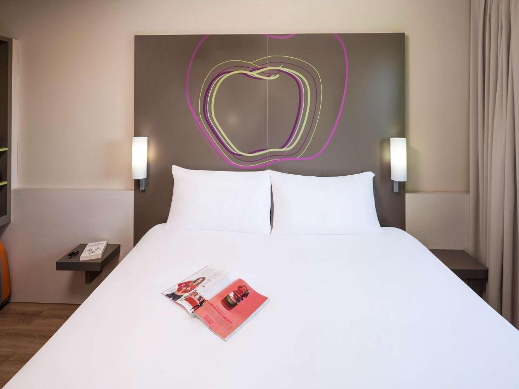 莱里达莱里达朵雷法勒拉宜必思尚品酒店 的卧室配有一张白色大床,墙上有心