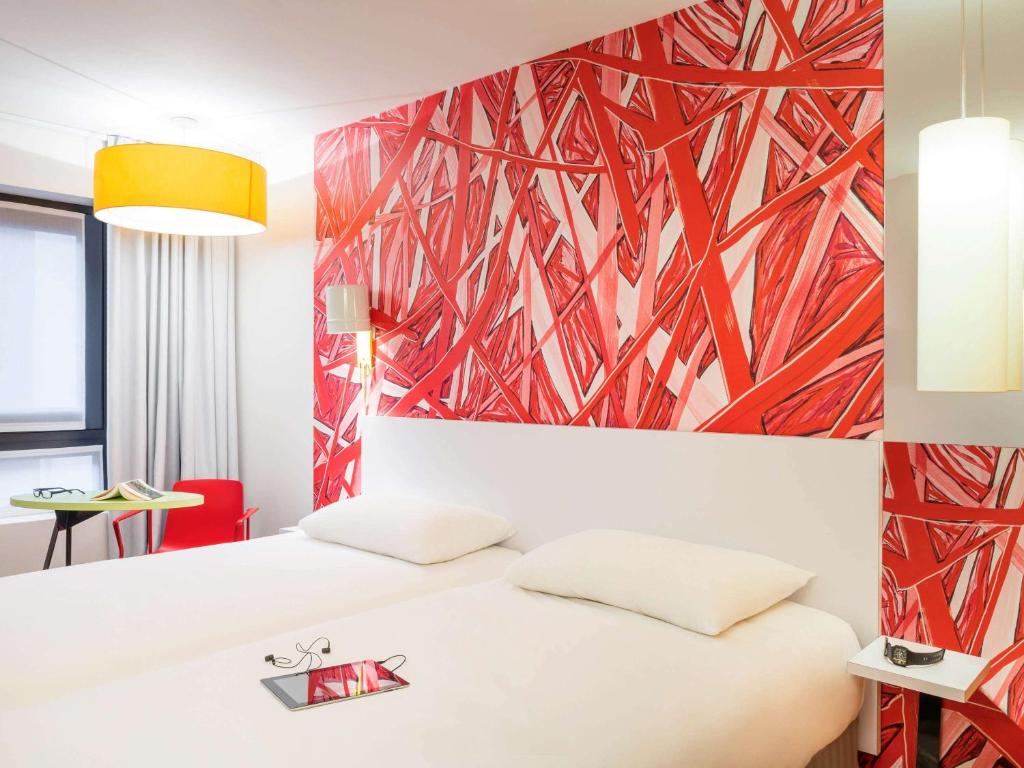 库尔布瓦库尔布瓦巴黎拉德芳斯宜必思尚品酒店的卧室配有白色的床和红色的墙壁