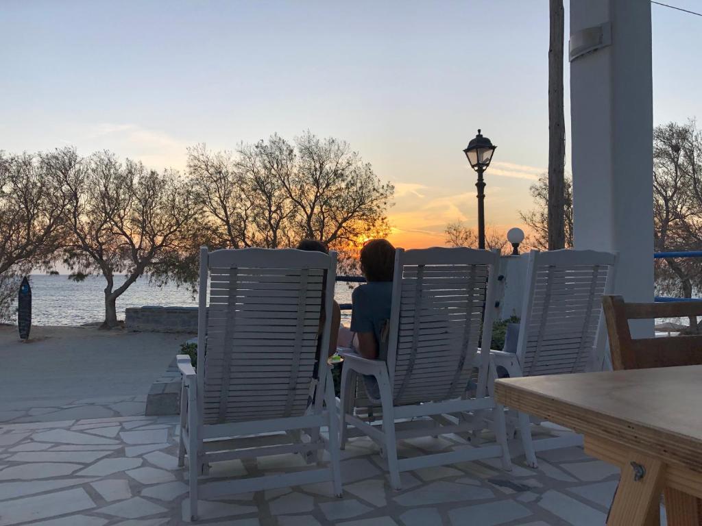 纳克索斯岛卡斯特拉基Akti Kastraki Beach的两个人坐在椅子上看日落