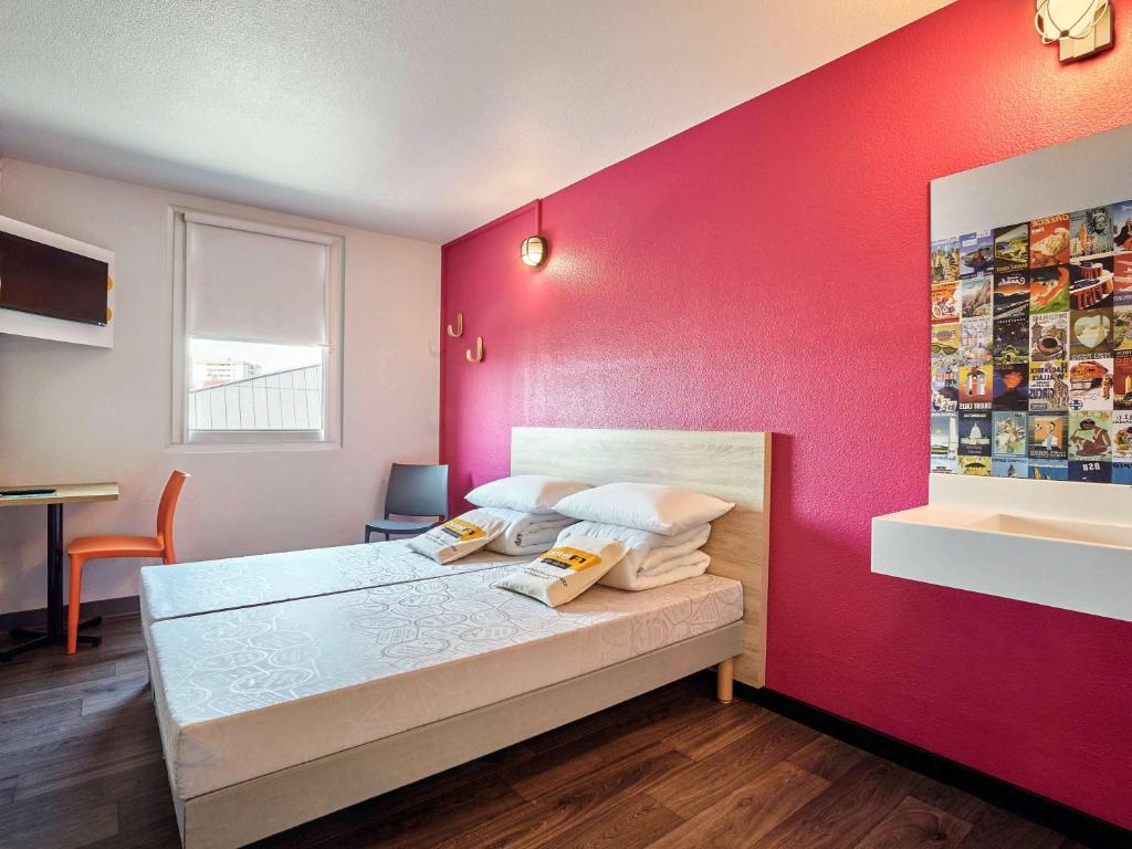 佩皮尼昂HotelF1 Perpignan Sud的一间卧室配有一张粉红色墙壁的床