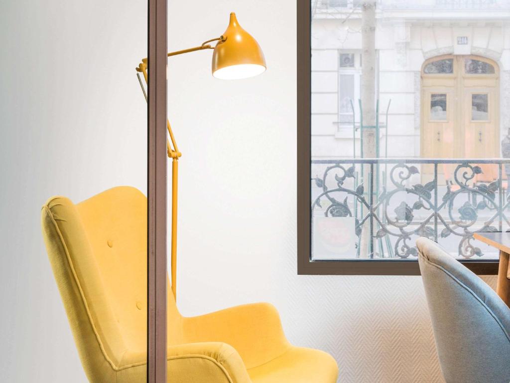 巴黎巴黎克里米亚拉维莱特宜必思尚品酒店的窗边的黄色椅子和灯