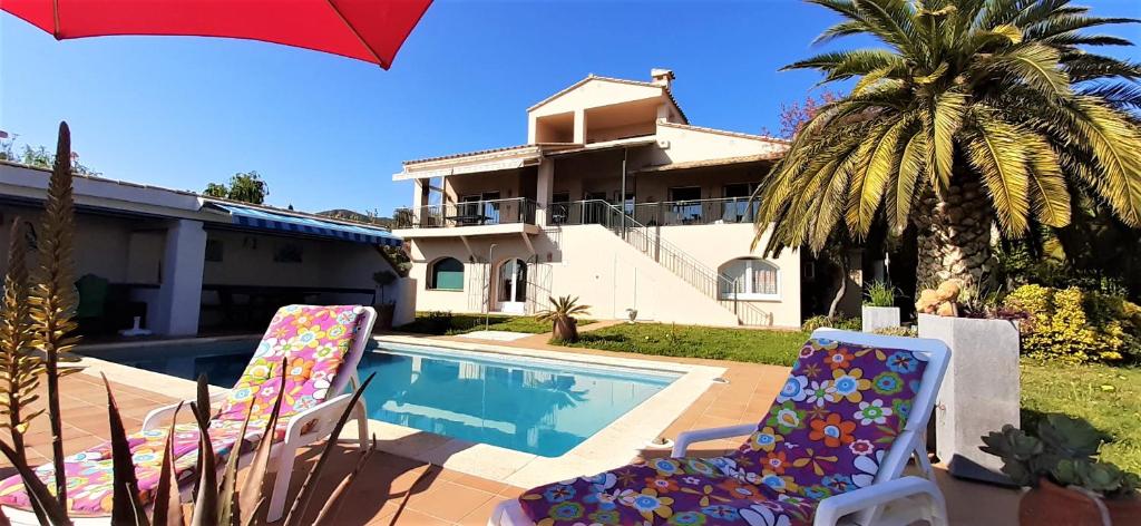 PauSuite & Spa Panoramic Olivars的一座带游泳池和两把草坪椅的房屋