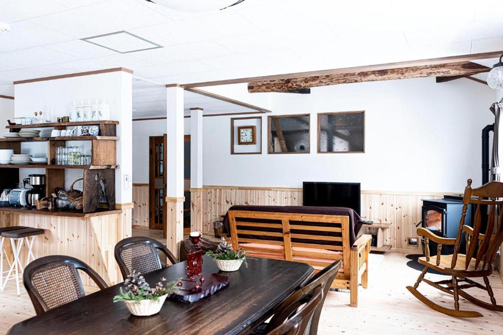 汤泽町Lakeside HANARE的客厅配有木桌和椅子
