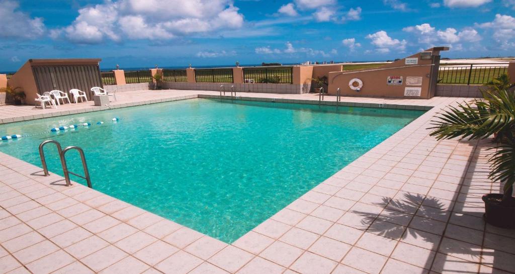塔穆宁SureStay Hotel by Best Western Guam Airport South的大楼内的一个蓝色海水游泳池
