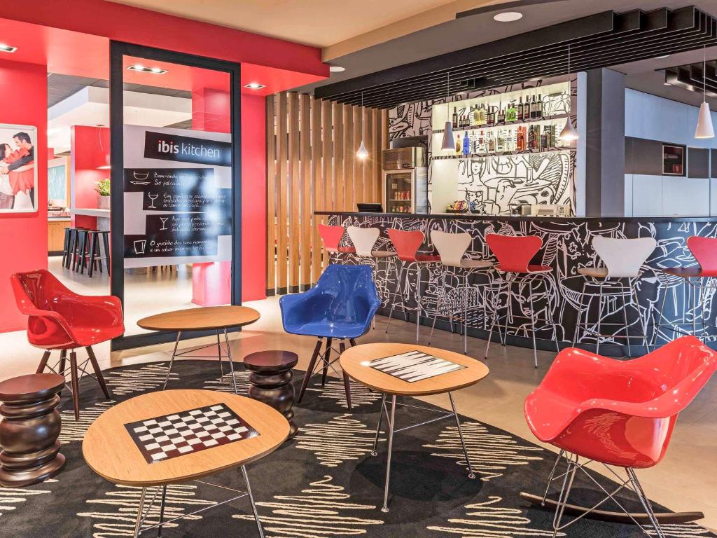 沙佩科ibis Chapeco的一间设有五颜六色椅子的餐厅和一间酒吧
